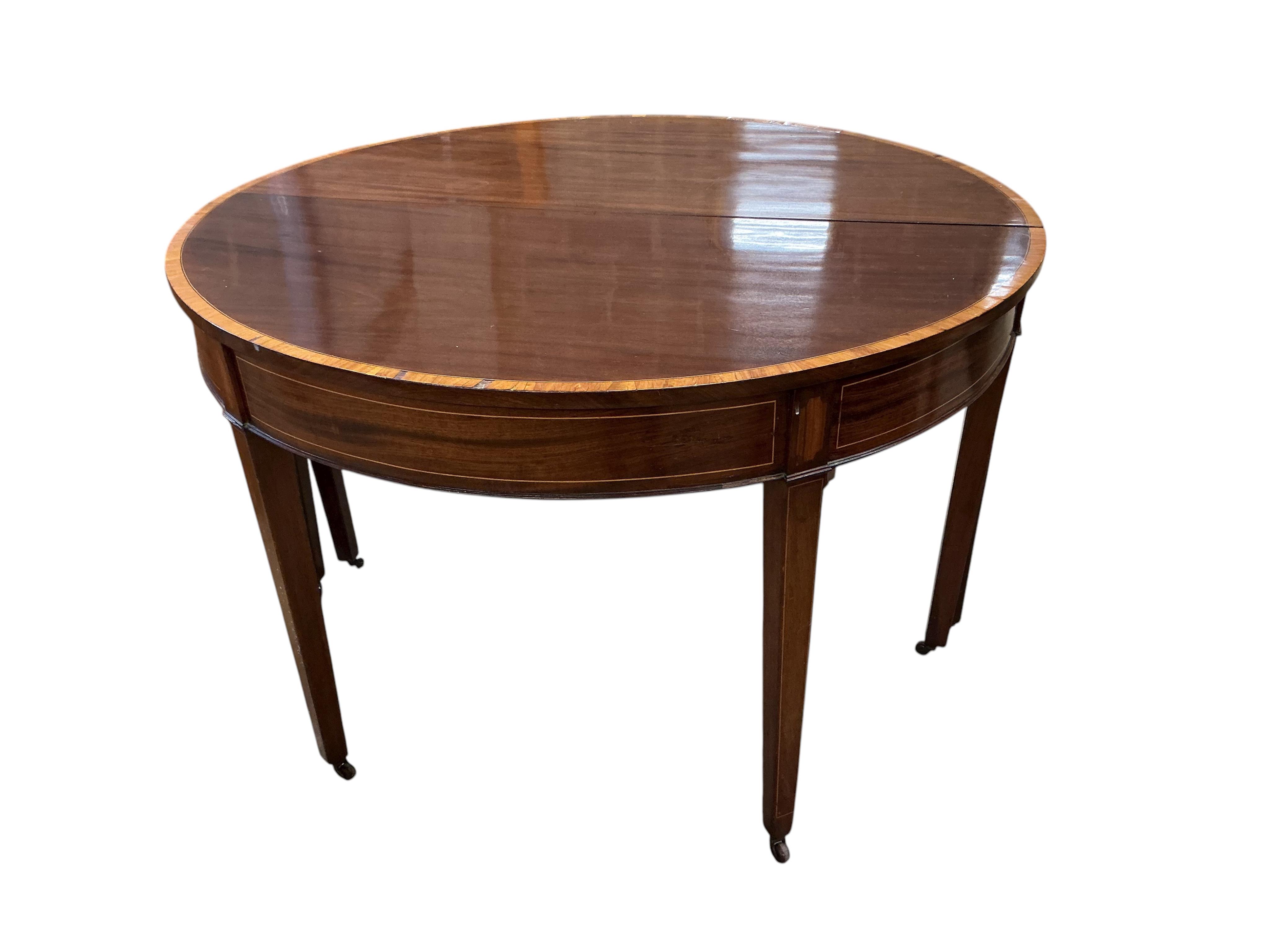 A George III satinwood banded mahogany D end extending dining table, with two spare leaves, 284cm extended, depth 120cm, height 74cm, together with a set of eight Victorian mahogany balloon back dining chairs